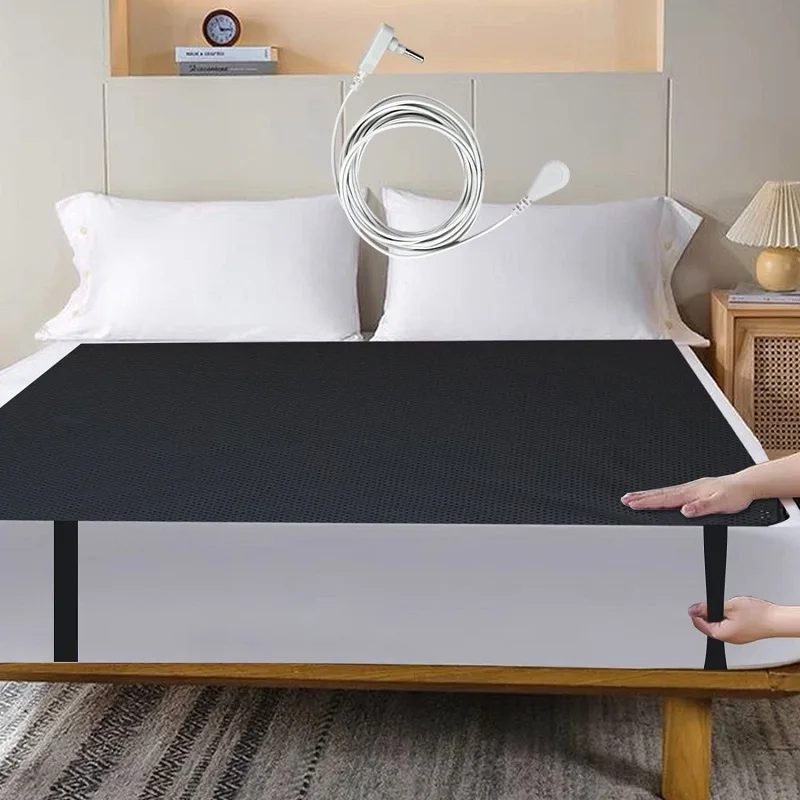 Un lit avec le tapis de lit noir, les oreillers et le cordon