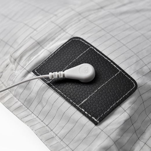 La pastille cousue sur le drap et le cordon clipsé